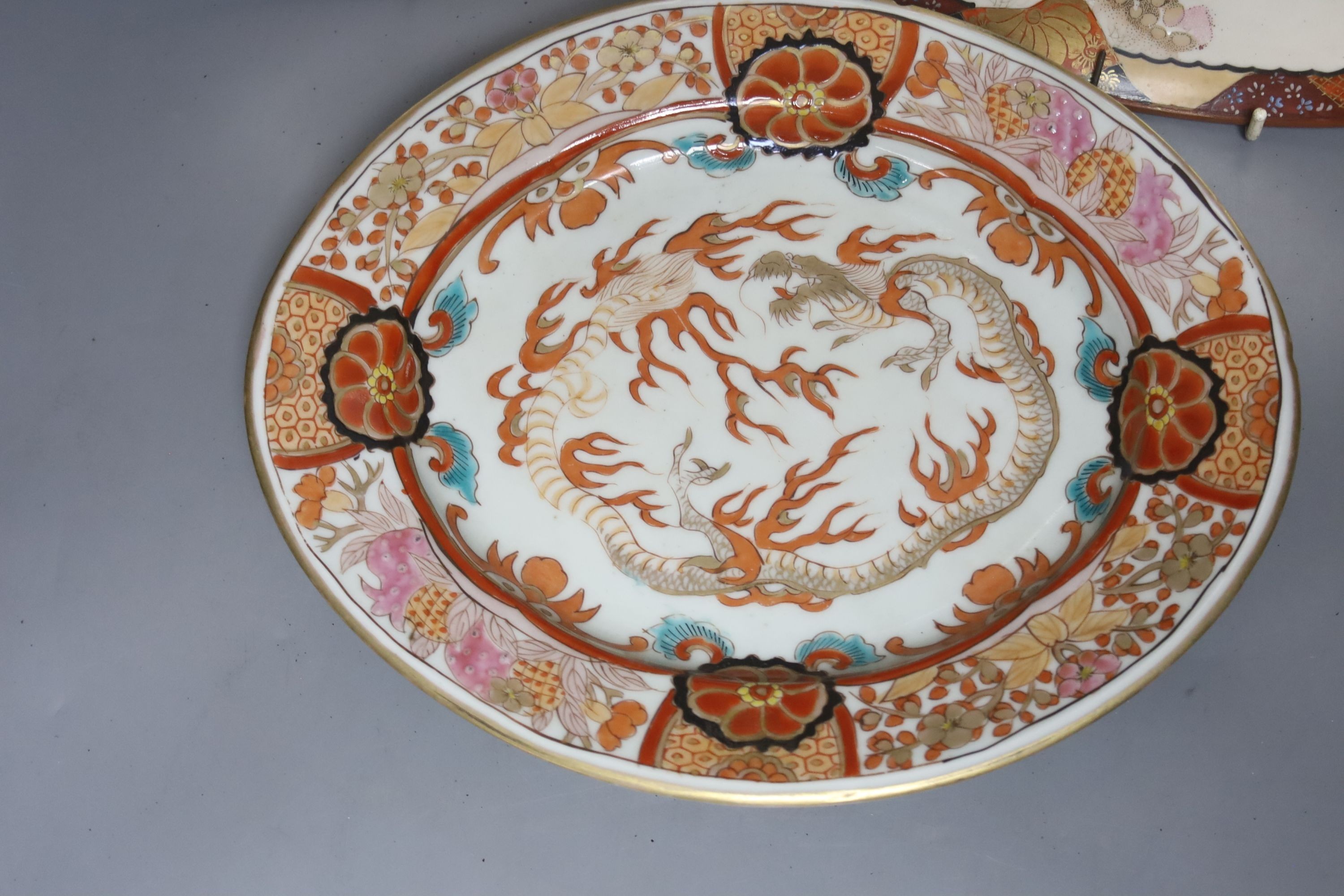 A late 19th century Japanese porcelain oval dish, 29cm, and a pair of Kutani style wall plates, 30cm